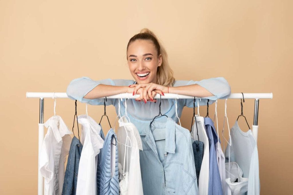 Moteris su minimalistine kapsuline spinta – šviesūs, universalūs drabužiai ir natūralus stiliaus džiaugsmas.