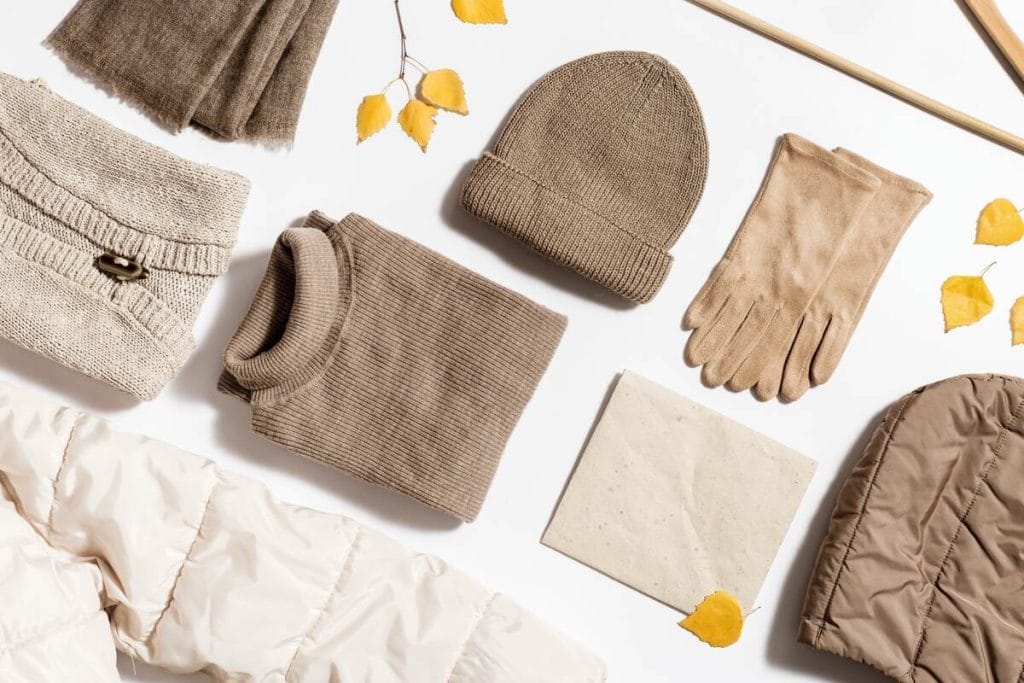 Rudų atspalvių žieminių drabužių ir aksesuarų derinys su megzta kepure