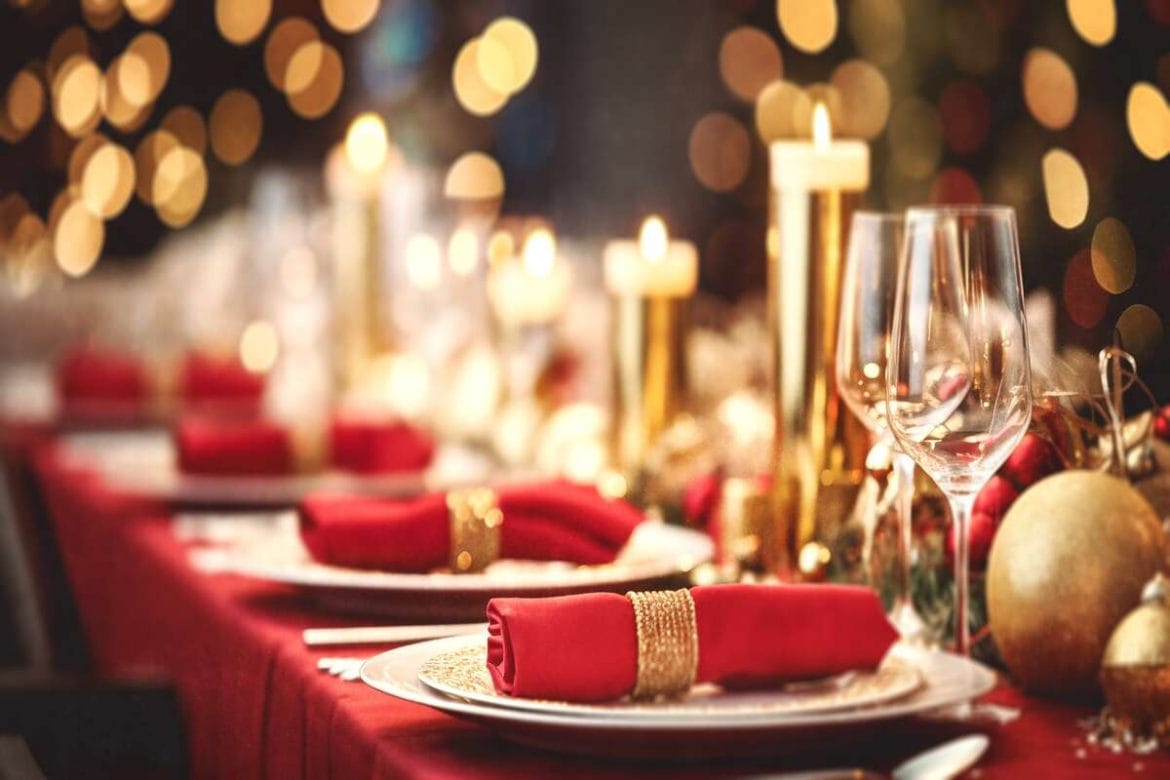 Elegantiškas kalėdinio stalo serviravimas su žvakėmis, švieselėmis ir prabangiais akcentais