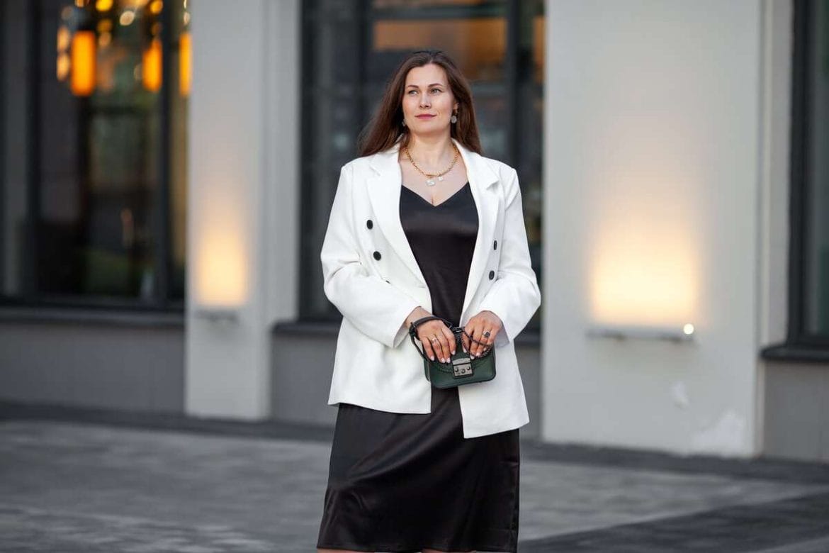 Vizualiai liekninantys drabužiai: baltas švarkas ir tamsi suknelė pabrėžia figūros linijas