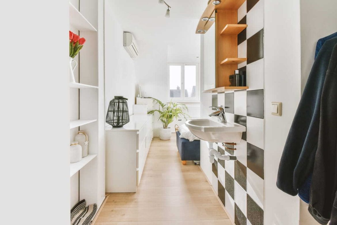 Mažo buto interjeras su siauru koridoriumi ir sumaniai išnaudota laikymo erdve