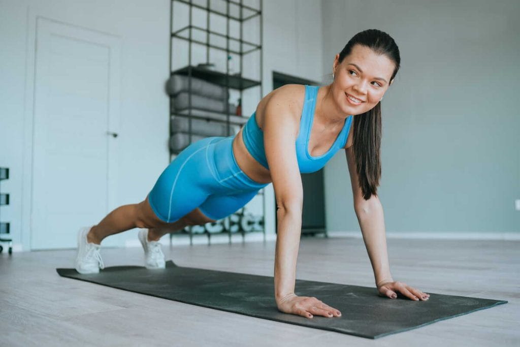 Sportinė apranga moterims atliekant pratimus ant kilimėlio namuose