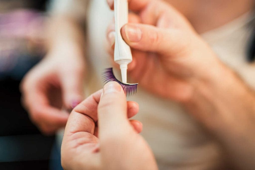 Rankose laikomos priklijuojamos blakstienos, ant jų tepami klijai prieš klijavimą