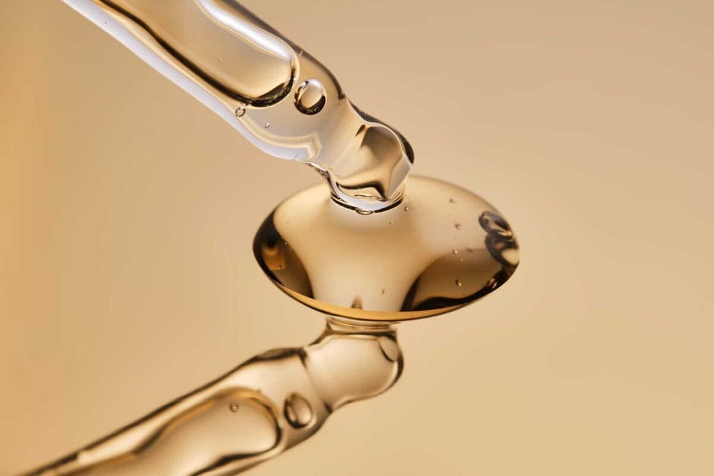 Retinolio serumo lašas ant pipetės – retinolio serumas dažnai naudojamas odos priežiūros rutinoje