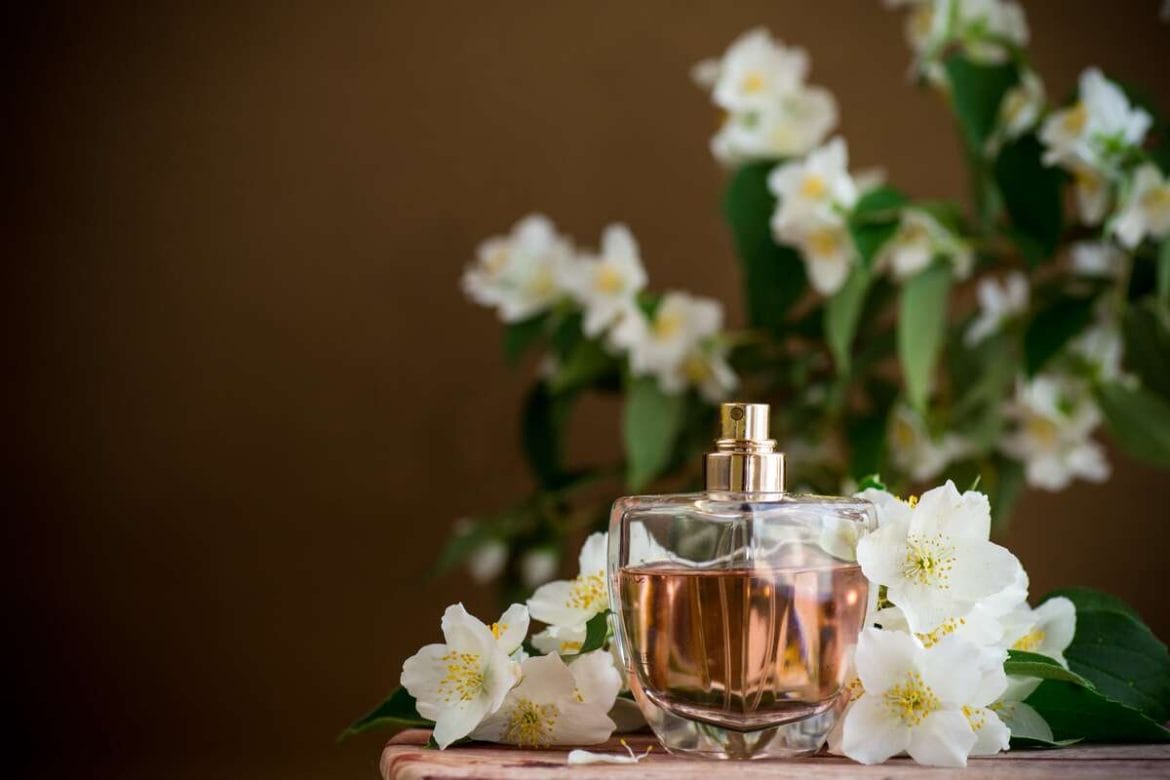 Stiklinis kvepalų buteliukas tarp jazmino žiedų – švelnus aromatas, tinkantis romantiško charakterio asmenybėms.