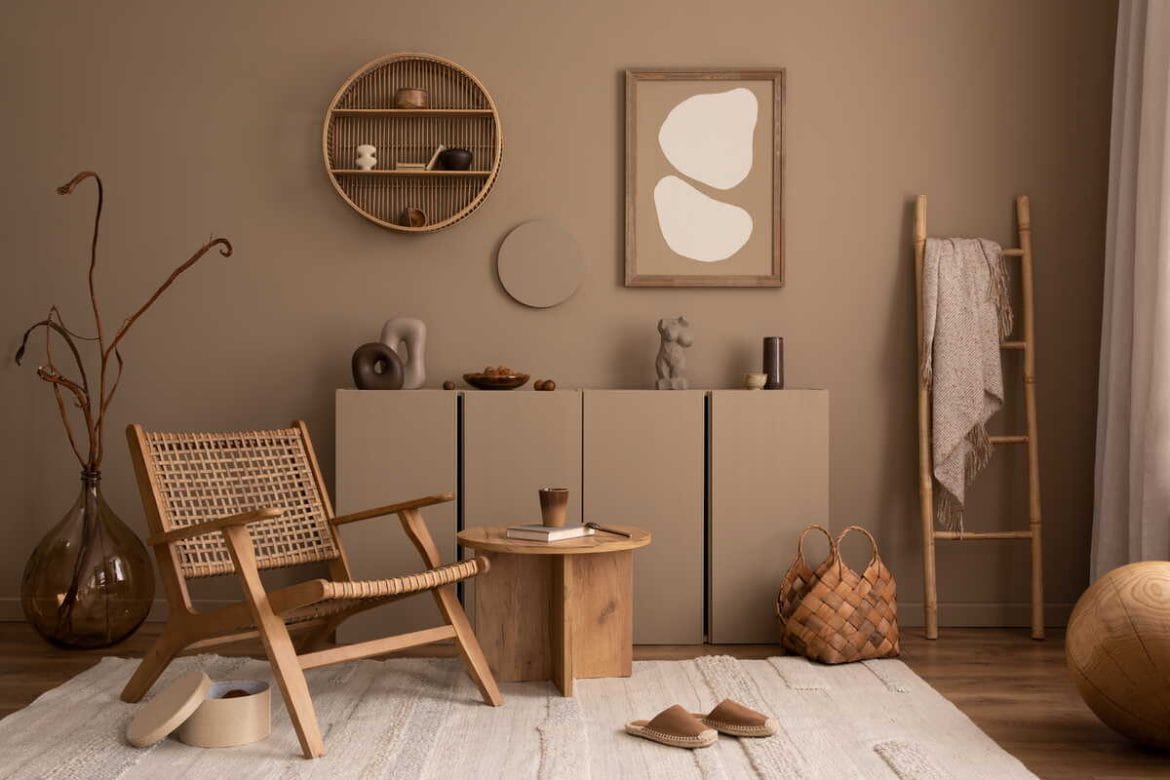 Šiltų atspalvių interjeras su sienų lentynomis, tekstūrinėmis detalėmis ir natūraliomis medžiagomis